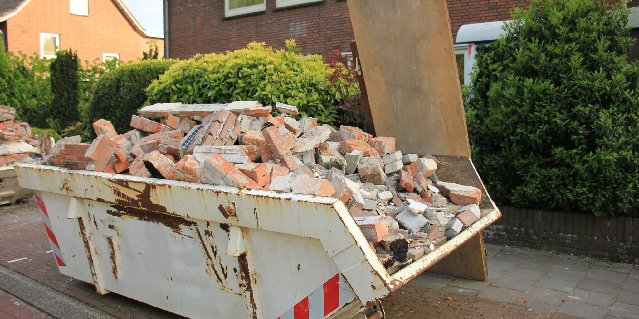 Loaded,Dumpster,Near,A,Construction,Site,,Home,Renovation